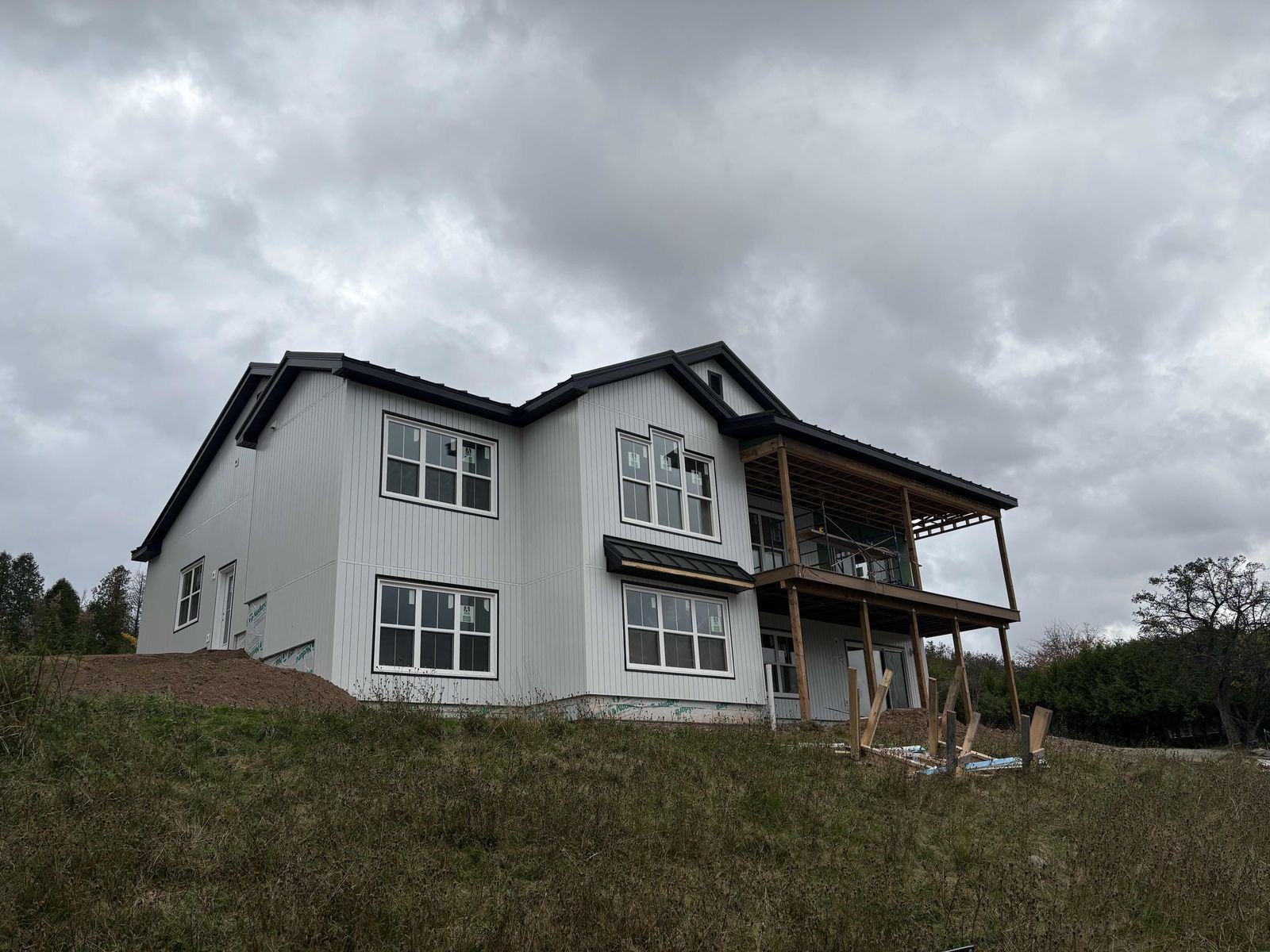The house nearly finished, with steel siding and the covered deck