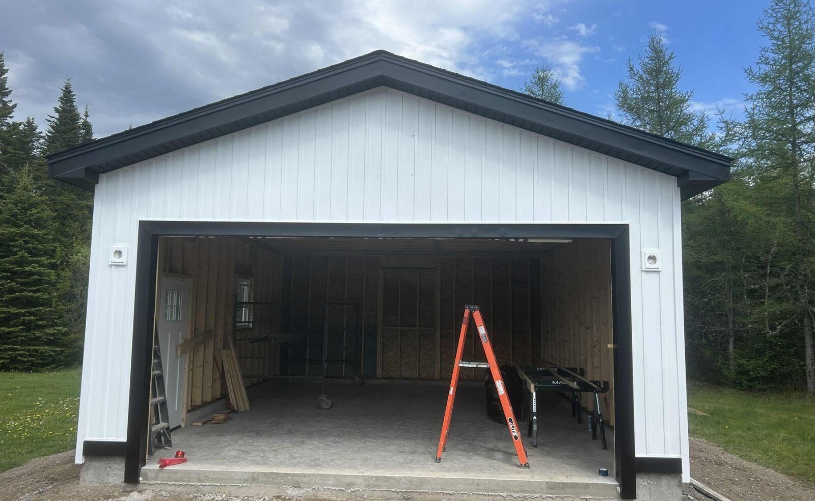 The new garage with white vertical siding